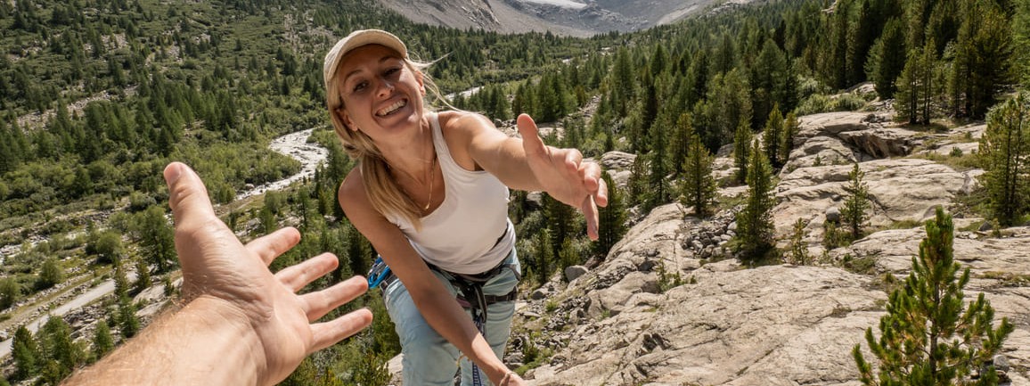 Eine Frau verlässt beim Bergsteigen ihre Komfortzone