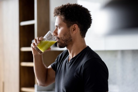 Ein Mann trinkt einen Saft mit Antioxidantien.