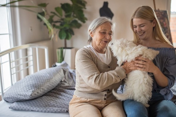 Eine Heimbewohnerin erhält eine tiergestützte Therapie mit einem Hund