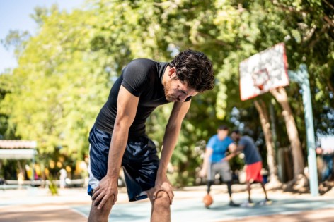 Ein Mann ist aufgrund großer Hitze beim Basketballspielen erschöpft