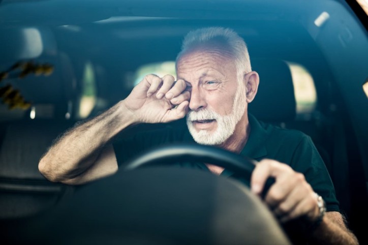 Ein Mann bemerkt Müdigkeit als Nebenwirkung beim Autofahren