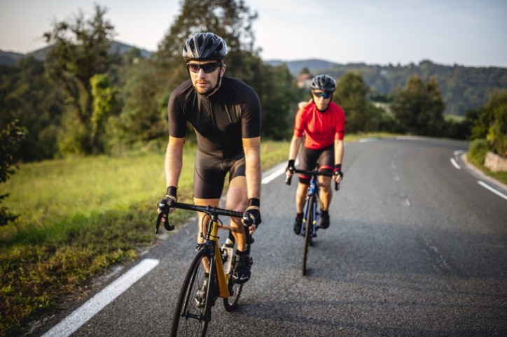 Zwei Personen absolvieren ein Cardio-Training auf ihren Fahrrädern.