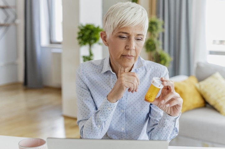 Ältere Dame begutachtet ihre Medikamente gegen Schizophrenie.