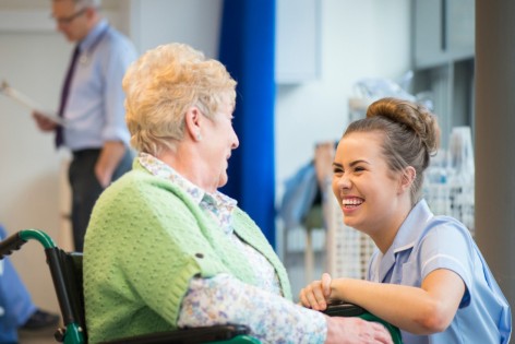 Eine Seniorin unterhält sich mit einer Krankenschwester über ihre Hüftoperation