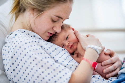 Frau hält ihr Baby in den Armen