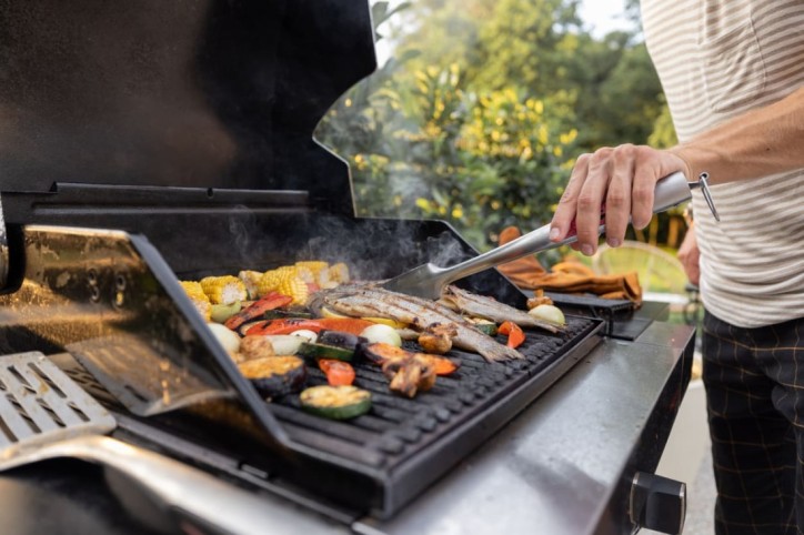 Ein Mann achtet beim Grillen auf die Sicherheit