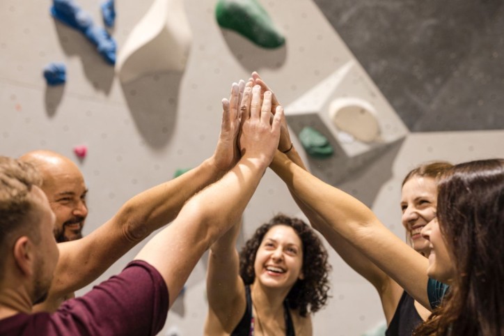 Eine Boulder-Kletter-Gruppe klatscht zusammen ab.