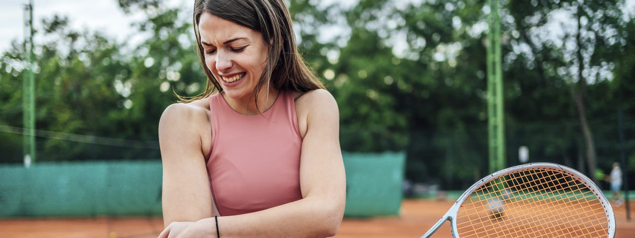 Eine Frau hat sich beim Tennisspielen eine Sportverletzung zugezogen