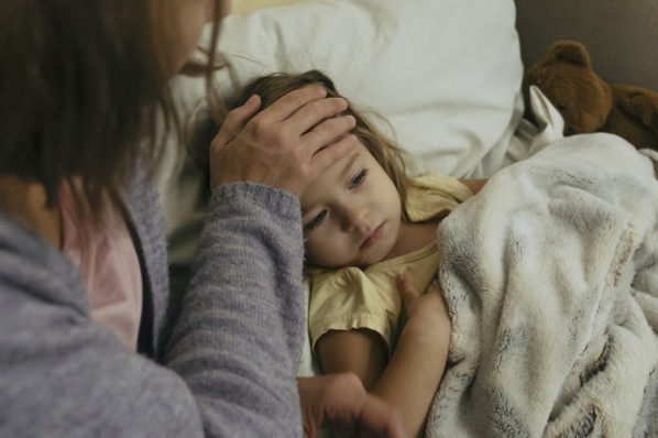 Eine Mutter sorgt für ihre Tochter, die unter dem Drei-Tage-Fieber leidet