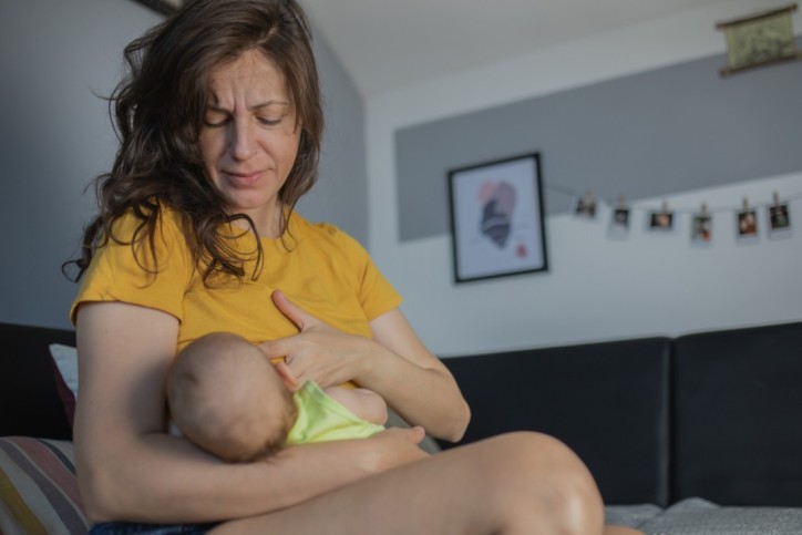 Eine stillende Mutter hat wunde Brustwarzen und nutzt Fettwolle zur Heilung.