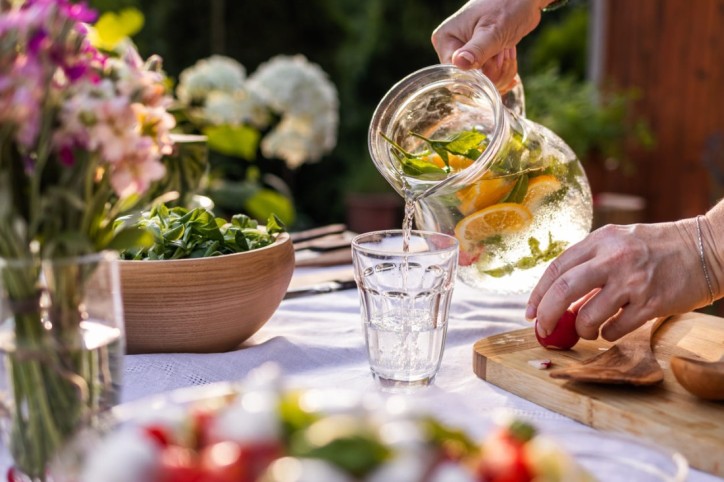 Infused Water wird gegen Flüssigkeitsmangel in ein Glas geschüttet