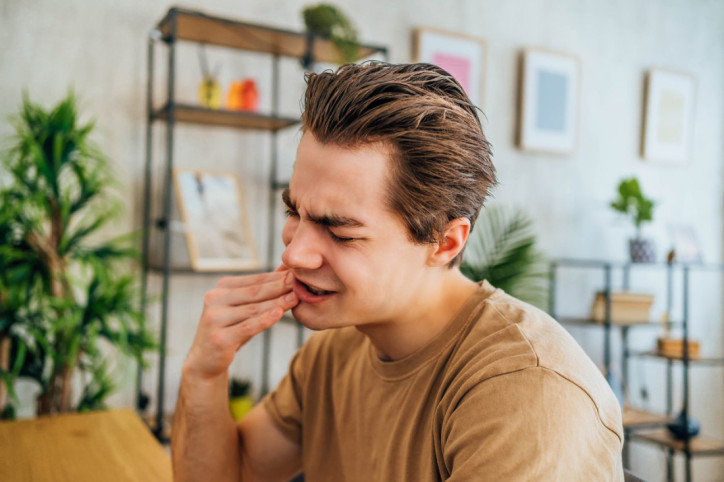 Ein junger Mann plant Teebaumöl gegen Entzündung im Mund zu nutzen