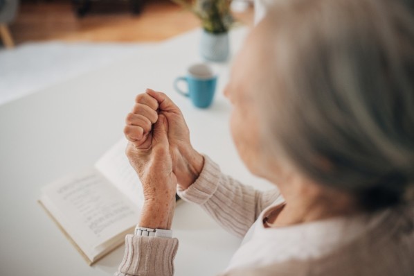 Seniorin verspürt Schmerzen im Handgelenk aufgrund einer rheumatoiden Arthritis.