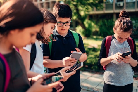 Schüler schauen gebannt auf ihre Smartphones.