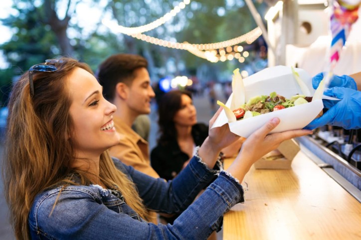 Eine Frau probiert kulinarische Spezialitäten auf dem Streetfood-Festival