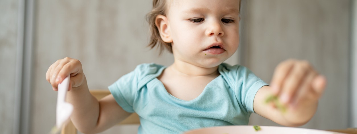 Ein Baby isst mit der Led Weaning Methode sein Essen.