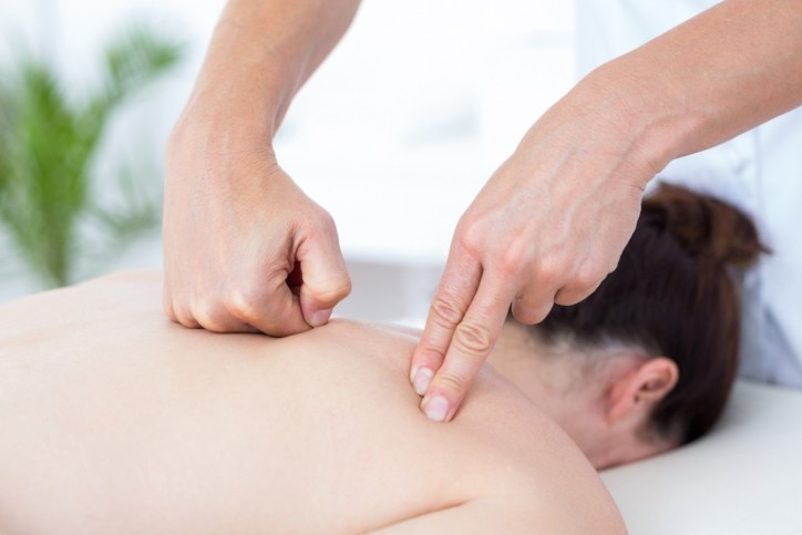 Physiotherapist doing back massage in medical office