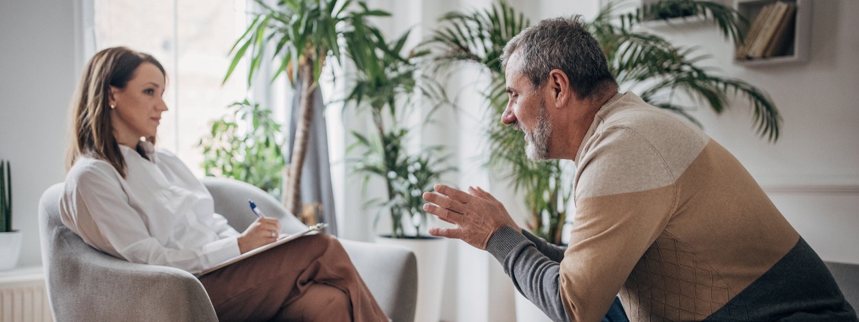 Eine Seniorin unterhält sich mit einer Krankenschwester über ihre Hüftoperation