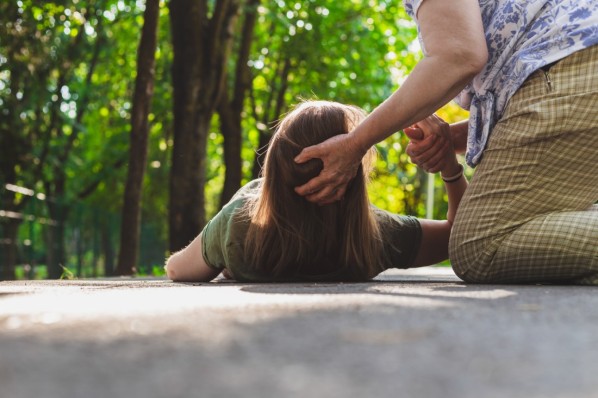 Einer Frau wird nach einem epileptischem Anfall geholfen