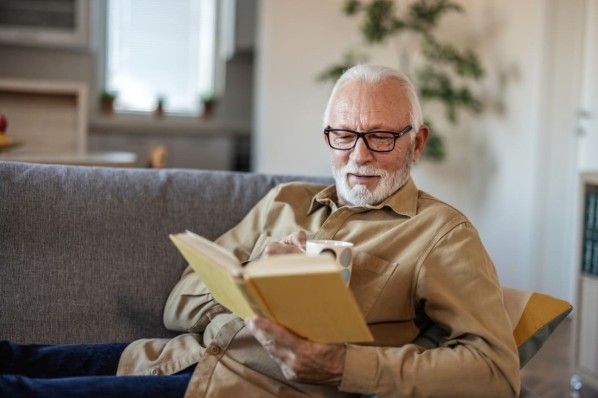 Ein älterer Mann liest ganz entspannt ein Buch