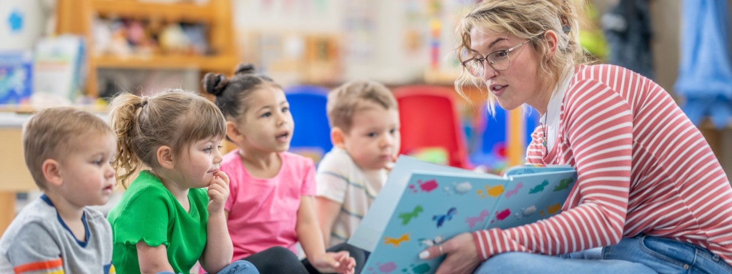 Eine Frau liest Kindergartenkindern zum bundesweiten Vorlesetag aus einem Buch vor.