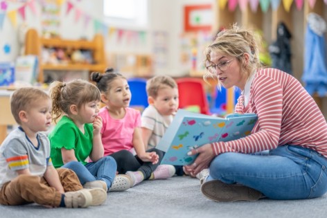 Eine Frau liest Kindergartenkindern zum bundesweiten Vorlesetag aus einem Buch vor.