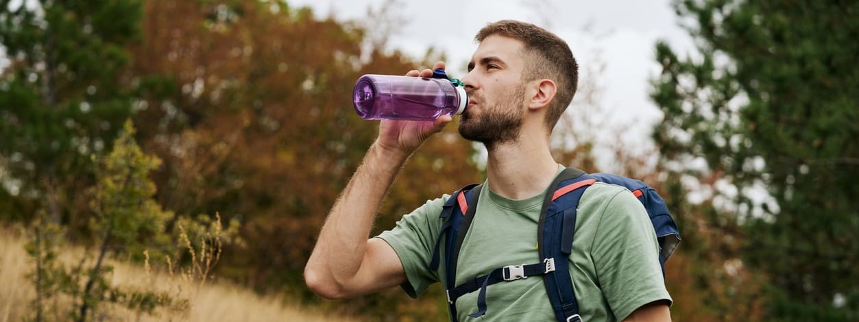 Ein Mann beugt beim Wandern einem Flüssigkeitsmangel vor