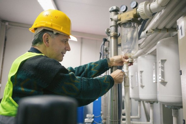 Senior man in a boiler room working. Shallow DOF. Developed from RAW; retouched with special care and attention; Small amount of grain added for best final impression. 16 bit Adobe RGB color profile.