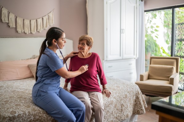 Pflegekraft untersucht Seniorin im Pflegeheim