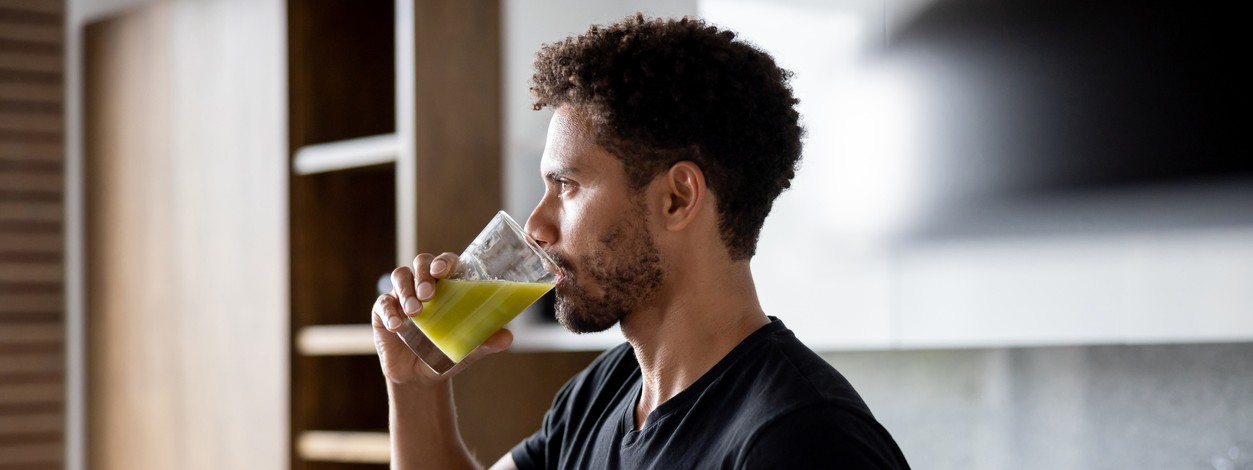 Ein Mann trinkt einen Saft mit Antioxidantien.