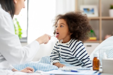 Ein kleines Mädchen wird auf eine Streptokokken-Infektion untersucht