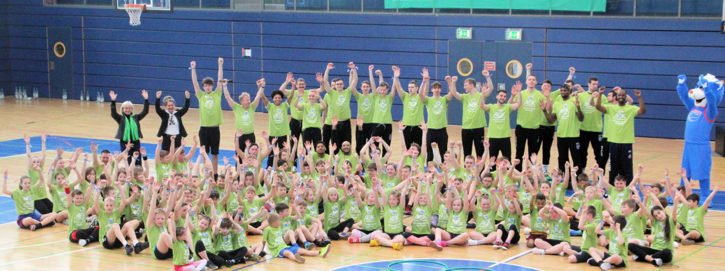 Kinder beim gemeinsamen Training mit den Profibaskettballern des SYNTAINICS MBC