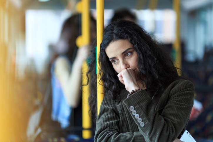 Eine Frau steht in einem Bus und kämpft gegen ihre Agoraphobie an